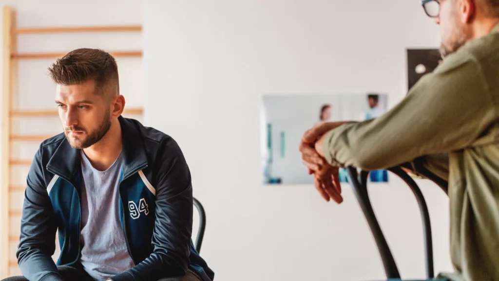 Man speaking to his doctor in the examination room. Text explains the benefits of outpatient treatment for alcoholism